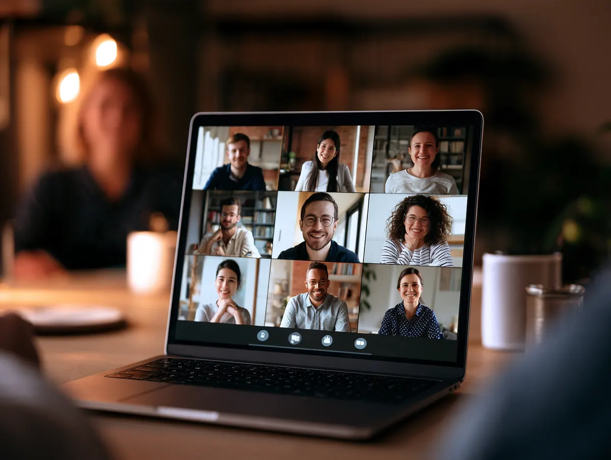 A laptop showing a video call with several participants during a webinar